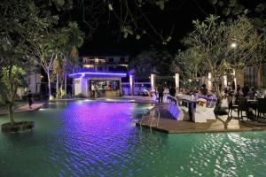 a swimming pool at night with people sitting at a table at Yeak Loam Hotel in Banlung
