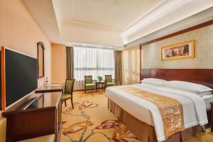 a hotel room with a large bed and a television at Vienna Hotel Shenzhen International Exhibition Center Fuhai Qiaotou in Shenzhen