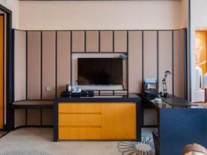 a living room with a flat screen tv on a wall at Jiuhua Jin Jiang International Hotel in Zhenjiang