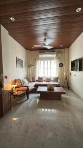 a living room with a couch and a wooden ceiling at House of Kashi Homestay- Studio and Budget Rooms in Kashi