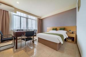 a hotel room with a bed and a desk at GreenTree Inn Nantong Zhangzhishan Town Deli Plaza Express Hotel in Nantong +138 photos
