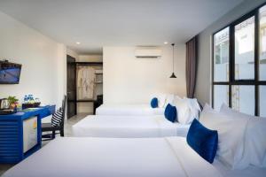 a hotel room with two beds and a desk at Popular Hotel & Spa in Siem Reap +170 photos