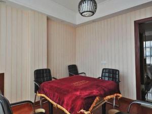 ein Raum mit einem Tisch mit Stühlen und einer roten Decke in der Unterkunft Vienna Classic Hotel Ningbo Xiangshan Wanda in Xiangshan