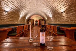 a bottle of wine on a wooden table with wine glasses at Hotel Rebschule in Freyburg +30 photos