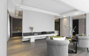 a living room with two chairs and a table at Shenyang Holz Hotel in Shenyang