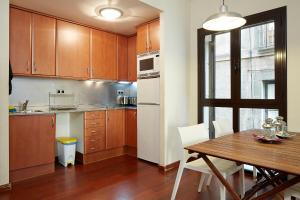 a kitchen with wooden cabinets and a wooden table at Olles Apartment in Barcelona