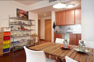 a kitchen with a wooden table and white chairs at Olles Apartment in Barcelona