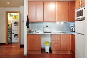 a kitchen with wooden cabinets and a sink at Olles Apartment in Barcelona