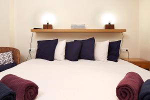 a bedroom with a large bed with blue and white pillows at Olles Apartment in Barcelona