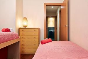 a bedroom with two beds and a dresser and a mirror at Olles Apartment in Barcelona