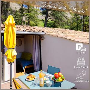 シストロンにあるLa Terrasse de la Citadelleの茶碗一杯の果物と黄色い傘