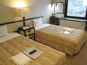 a hotel room with two beds and a window at Ako Royal Hotel in Himeji