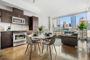a kitchen and living room with a table and chairs at Downtown Chic Retreat | Elegant + Free Parking in Calgary