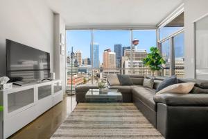 a living room with a couch and a large window at Downtown Chic Retreat | Elegant + Free Parking in Calgary