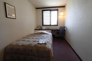 a bedroom with a bed and a desk and a window at HotelYama in Nagano +40 photos