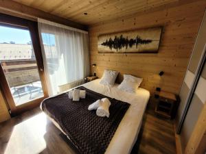 レ・ジェにあるRésidence Cry De Lys - Appartement entièrement rénové, au pied des pistes MAE-8491のベッドとタオル2枚のある寝室