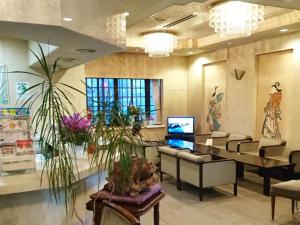 a lobby with a waiting room with couches and plants at Hotel Four C's in Nihommatsu +73 photos