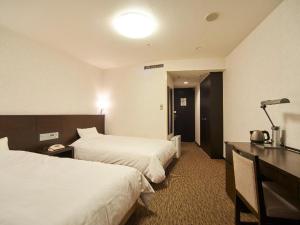 a hotel room with two beds and a desk at Osaka Dai-ichi Hotel in Osaka +120 photos
