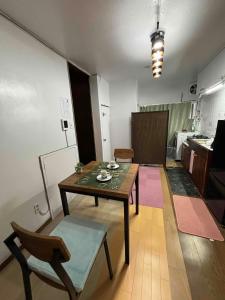 a living room with a table and a kitchen at I Love SHIN-OSAKA in Osaka