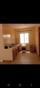 a kitchen with a sink and a window in it at Chez DiDi in Mbodiène