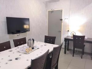 a dining room with a table and a television at Pice Hotel in George Town