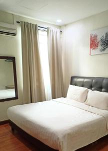 a bedroom with a bed with a mirror and a window at Hotel Seri Pauh in Jalan Baharu