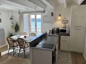 Una cocina con mesa y sillas y un refrigerador. en Duplex rénové avec vue exceptionnelle sur le port d’Erquy, en Erquy