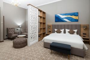 a bedroom with a bed and a desk and a chair at Tauke Khan Plaza in Shymkent +122 photos