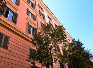 un edificio naranja con un árbol delante de él en CdR Guest House, en Roma