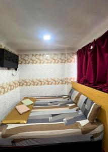 a bed in a room with a red window at New Wave Hotel Melawati in Taman Melawati