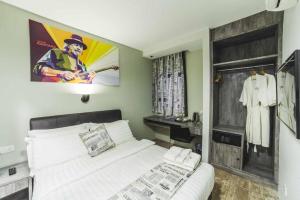 a bedroom with a white bed with a poster on the wall at Nginap Hotel in Subang Jaya