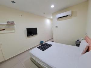 a bedroom with a bed and a tv on the wall at OYO 90442 Newtown Star Hotel in Klang