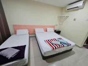 a bedroom with two beds with towels on them at OYO 90442 Newtown Star Hotel in Klang +67 photos