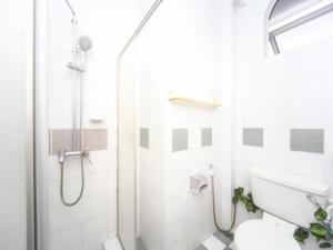 a white bathroom with a shower and a toilet at OYO 563 Jockey Lodge Hotel in Sandakan +70 photos