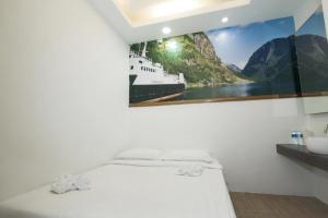 a bedroom with a picture of a ship on the wall at Hotel Zamburger Zamway Lagoon in Petaling Jaya
