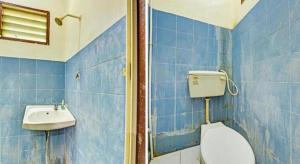 a blue tiled bathroom with a toilet and a sink at OYO 90278 Redzwan's Beach Resort in Kota Bharu