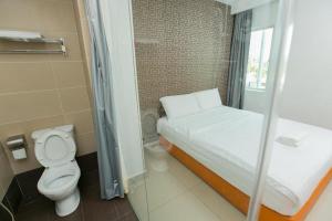 a small bathroom with a bed and a toilet at 1 Hotel Mahkota Cheras in Kampong Perimbun