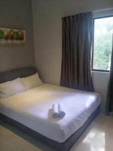 S Avenue Hotel في جوهور باهرو: سرير عليه زوجين من الاحذية