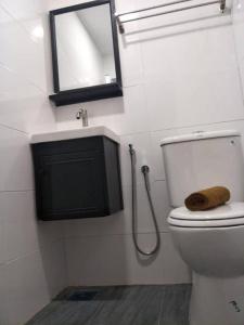 S Avenue Hotel في جوهور باهرو: حمام مع مرحاض مع حوض ومرآة