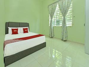 a bedroom with a bed with red pillows and a window at OYO Home 90584 Dz Homestay Bukit Setongkol in Kampong Darat Tanah Puteh