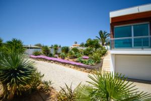 a house with palm trees and a driveway at Palmares Beach, Golf & Dream in Lagos