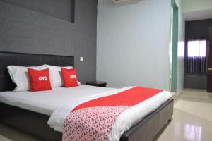 セリ・マンジュンにあるOYO 89737 Hotel Tishoaのベッドルーム1室(大型ベッド1台、赤い枕付)