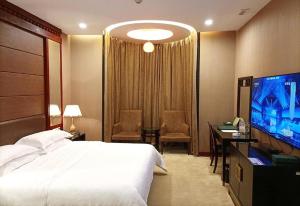 a hotel room with a bed and a flat screen tv at OSOTTO RECREATION HOTEL in Foshan