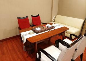 a living room with a table and a couch at OSOTTO RECREATION HOTEL in Foshan