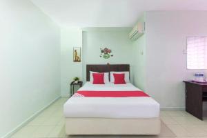 a bedroom with a large bed with red pillows at OYO 90118 Suntex Hotel in Kampong Baharu Cheras Batu Sembilan