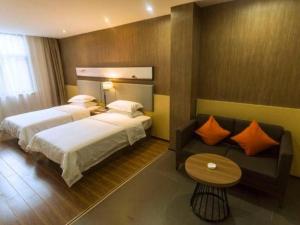 a hotel room with a bed and a couch at Jtour Inn Suizhou Yanhe Avenue in Suizhou