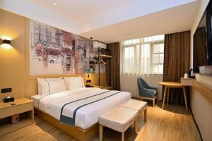 a hotel room with a large bed and a chair at City Comfort Inn Kunming Nanping Pedestrian Street Wangfujing in Kunming