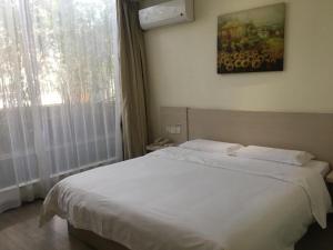 Hanting Hotel Shenzhen Baoan Xixiang Taoyuanju客房内的一张或多张床位
