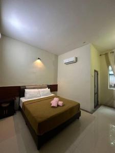 - une chambre avec un lit et 2 serviettes roses dans l'établissement OYO 90938 The NK Langkawi, à Kampung Padang Masirat