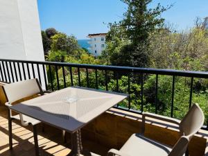 Un patio con una mesa y sillas en un balcón. en Palmeras 15, en Nerja